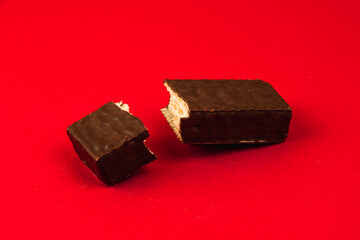 Sweets food concept, composition of slice chocolate waffle bars on a red background, flat lay, copy space