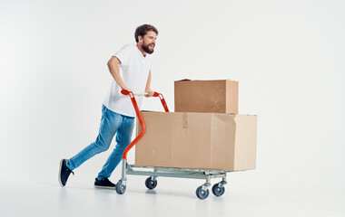 bearded male courier with cardboard boxes on a cargo trolley