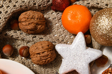 sweet food background for christmas or holiday decoration - tangerines, nuts and dried fruits on wool