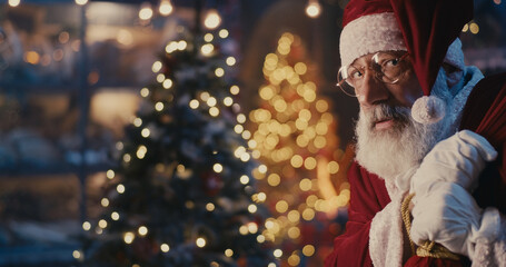 Fototapeta na wymiar Happy Santa Claus walking quietly near Christmas tree