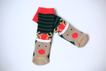 Creative layout made with Christmas Striped green socks. Minimal New Year season concept. Top view, flat lay. Xmas winter warm new socks with deers on white background, isolated. Santa stocking.  
