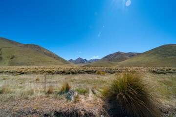 Peaks and tussock covered valleys of Lindis Pass, famous road trip.