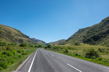 Highway stretches out ahead running between mountains.