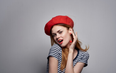 woman in red beret and striped t-shirt cropped view gray background model