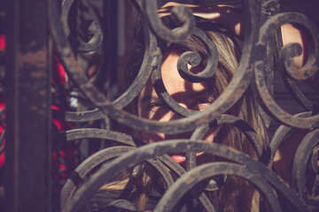 artistic portrait of a woman behind metal structures