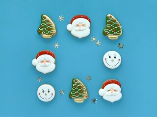 gingerbread square frame: Santa Claus, Christmas tree and snowman on blue background, silver snowflakes