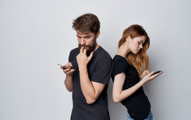 young couple in black t-shirts with phones in hands communication internet technology