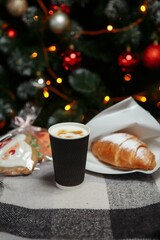 Christmas coffee and croissants with gifts and toys on the background of the Christmas tree