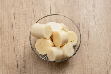 Bowls filled with palmitos or heart of palm cut into slices on a wooden surface. Concept natural food, healthy food.