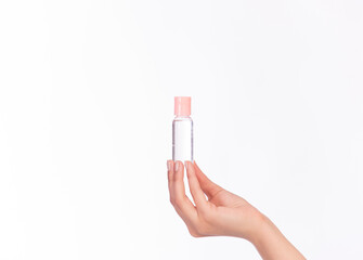 Female hand holding cosmetic bottle, different package, isolated with copy space. Liquid disinfection, cleaner or cosmetic care concept