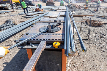 The construction worker is bending rebars. Rebar (rod, reinforcing bar), known when massed as reinforcing steel or reinforcement steel, is a steel bar or mesh of steel wires used as a tension device.