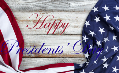 Fototapeta na wymiar Happy Presidents Day text with draped US flag on bottom of white rustic wood