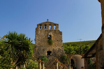Fototapeta na wymiar Stone bell tower of an ancient Orthodox church on the Peloponnese island (Greece)