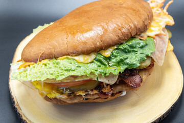 Fototapeta premium Mexican bun sandwich Torta perfectly prepared on the grill stacked with lettuce, veggies and meat.