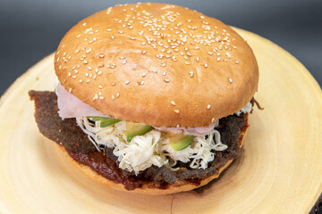 Mexican bun sandwich burger perfectly prepared on the grill stacked with veggies and meat.