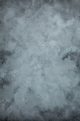 Grey hand-painted concrete background texture with dark and light spots and vignetting