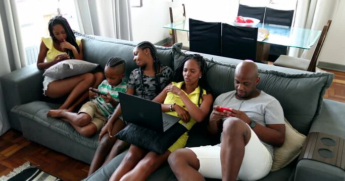 African family parents and children using technology at home sofa