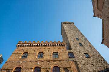 Low angle view of the ancient buildings and Torre Grossa in San Gimignano - obrazy, fototapety, plakaty