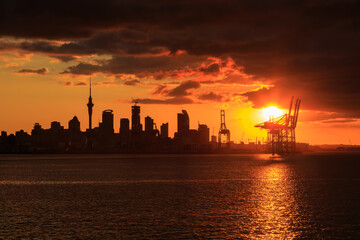 Fototapeta na wymiar The skyline of Auckland, New Zealand, silhouetted at sunset