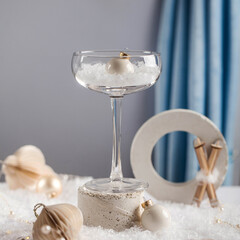 Modern new year's still life. Glass on the podium with Christmas balls. Art concept of Christmas.