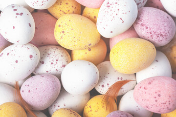 Easter holidays decoration. Funny colourful decorative chocolate Easter eggs background. Close-up. Top view. White yellow pink eggs for Easter treat.