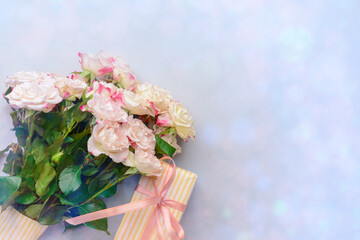 Gift box and bouquet of beautiful flowers on light background
