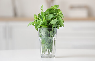 Glass with fresh mint on table in kitchen