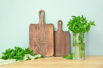 Fresh mint and wooden board on kitchen table
