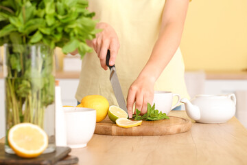 Woman cutting mint in kitchen