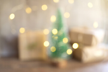Blur image of christmas tree and gift boxes with warm light bokeh.