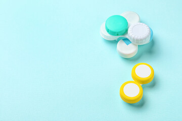 Containers with contact lenses on color background