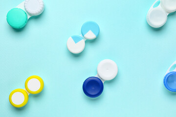 Containers with contact lenses on color background