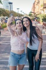 Two latin women taking a selfie outside