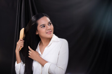 Woman takes care and comb her long black hair