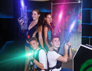 Fototapeta na wymiar . portrait of team of players with pistols in their hands in dark laser tag room