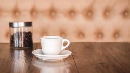 Coffee cup and saucer on a wooden table. Dark background.