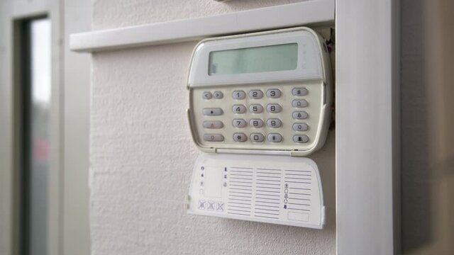 Hand entering alarm system password of an apartment, home or business office. Surveillance and protection console against rubbery and thief