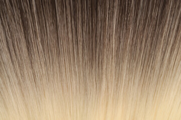 close up texture of single piece clip in straight brown blended to blonde two tone ombre style...