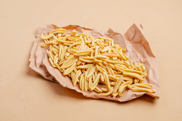 Yellow dry pasta on parchment paper
