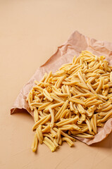 Yellow dry pasta on parchment paper