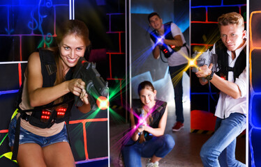 Group of young positive people playing enthusiastically laser tag game in dark room