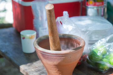 Mortar and pestle and raw materials that will be used to make papaya salad.