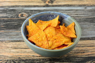Taco flavored corn tortilla chips in ceramic snack bowl in table