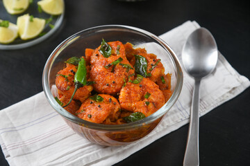Top view spicy hot Bengali Prawn roast , shrimp masala Kerala fish curry. Indian food. Fish fry with red chili, curry leaf. Asian cuisine. Delicious  Goan fish curry clay pot. Grilled tiger shrimps