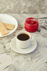 Crispbread with jam for Breakfast on a gray background. A jar of Fresh Honey with foam is next to a Cup of coffee. A minimum of calories. proper nutrition