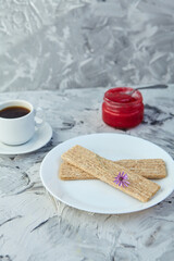 Crispbread with jam for Breakfast on a gray background. A jar of Fresh Honey with foam is next to a Cup of coffee. A minimum of calories. proper nutrition