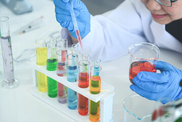 Asian female scientist doctor working in to research and concentrated making experiment in laboratory