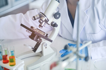 Medical research scientist using the microscope in chemical lap