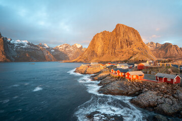 Landscape of red fishing rorbuer house village with sunrise light and mountain view in Lofoten island Hamnoy Norway