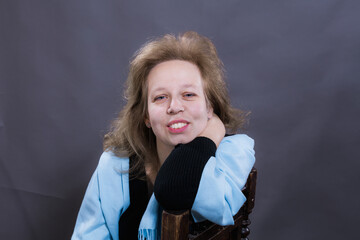 Cheerful 40 years old woman sitting pn chair studio portrait.